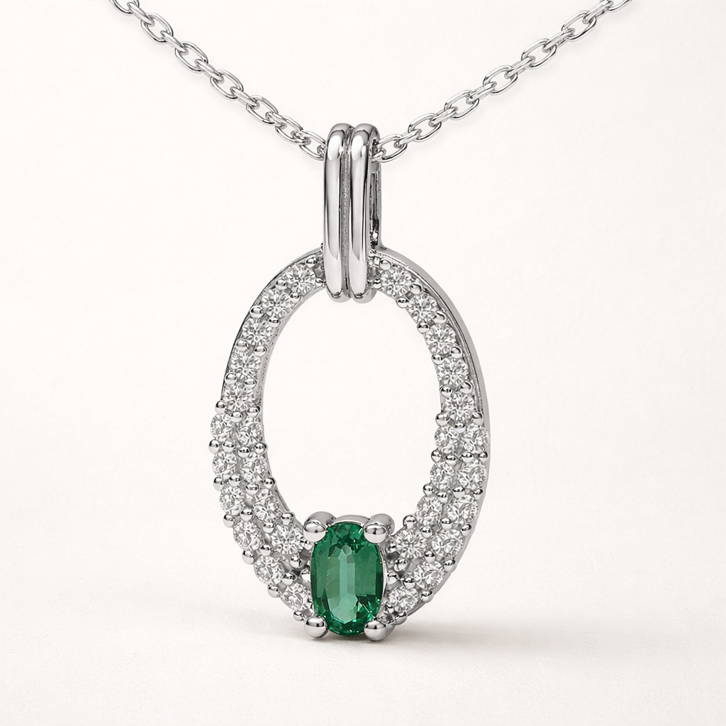 Silver pendant necklace featuring a green emerald center stone surrounded by a halo of clear stones